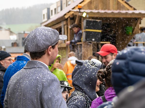 A shot of the famous Carnival event "Calvalcade" in Diekirch. In the background, a parade float is surrounded by many costumed spectators.