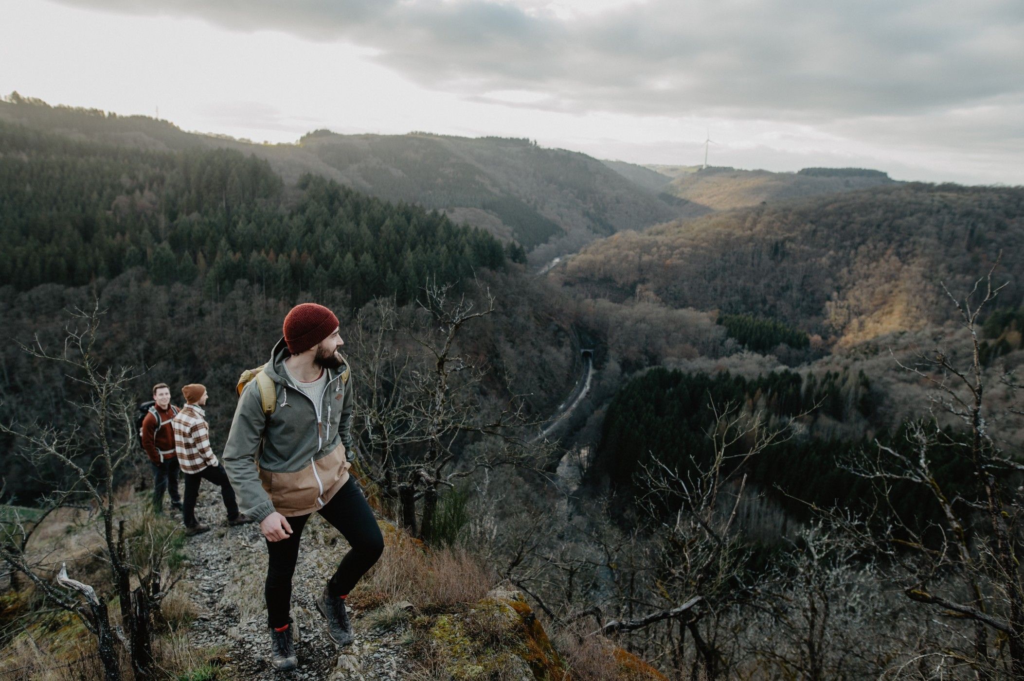 Des personnes montent la montagne en automne ; le paysage est dépouillé.